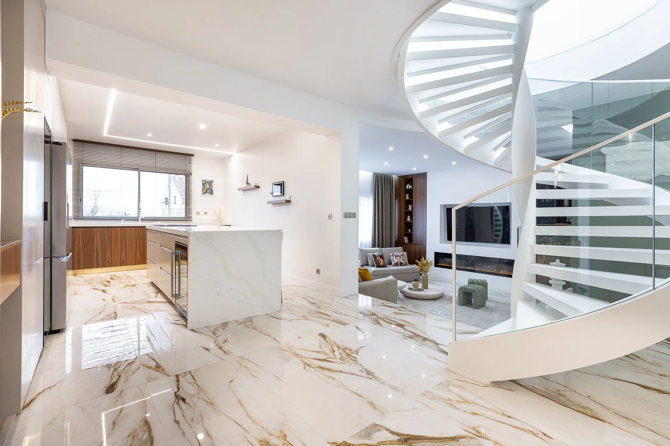 Séjour ouvert avec escalier hélicoïdal et sol en marbre