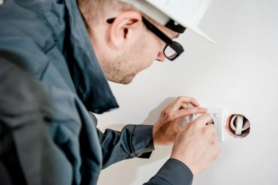 Photo d'illustration — pose d'une prise murale par un électricien